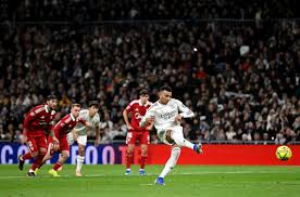 Kylian Mbappe equalled Cristiano Ronaldo's record of 59 goals in a calendar year for Real Madrid in a hard-fought win over Sevilla which kept up the pressure on La Liga leaders Barcelona.
